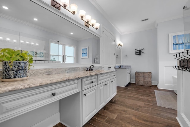 bathroom featuring hardwood / wood-style flooring, ornamental molding, and vanity