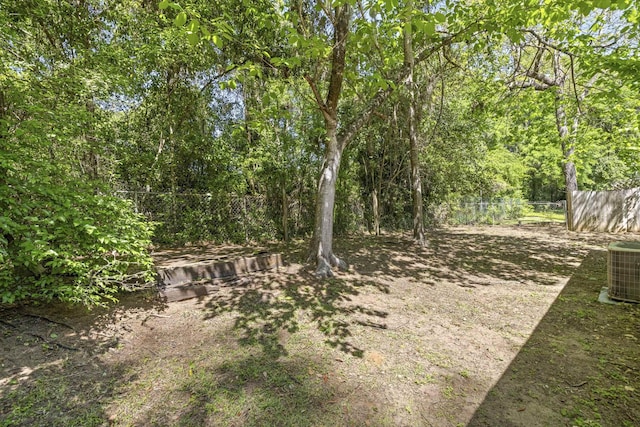 view of yard featuring fence and central air condition unit