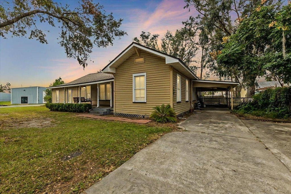 view of front of property featuring a carport and a yard