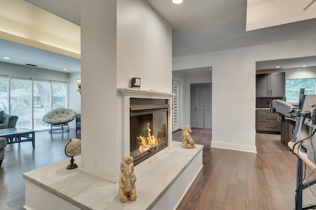 2414 Glenshire Ln, Tallahassee, FL 32308 - living room featuring a glass covered fireplace, dark wood finished floors, baseboards, and recessed lighting