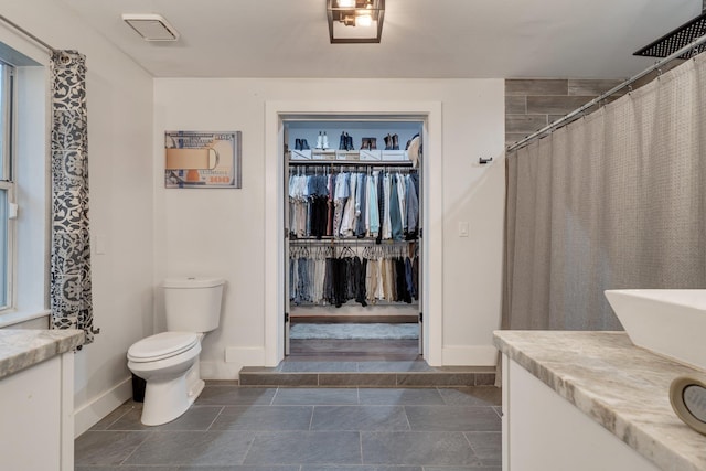 2414 Glenshire Ln, Tallahassee, FL 32308 - full bathroom with toilet, vanity, baseboards, a spacious closet, and a shower with shower curtain