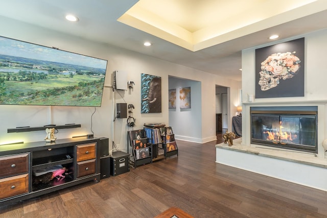 2414 Glenshire Ln, Tallahassee, FL 32308 - living room with dark wood-style flooring, a glass covered fireplace, recessed lighting, baseboards, and a tray ceiling