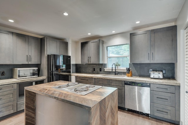 2414 Glenshire Ln, Tallahassee, FL 32308 - kitchen featuring stainless steel appliances, a sink, tasteful backsplash, light wood finished floors, and recessed lighting