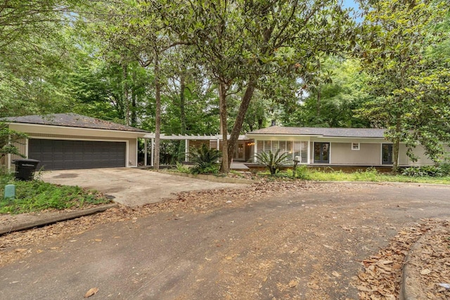 2414 Glenshire Ln, Tallahassee, FL 32308 - ranch-style house featuring driveway, a garage, and view of wooded area