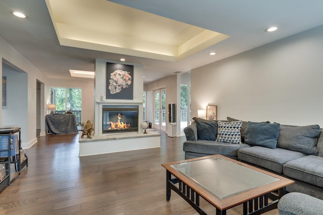 2414 Glenshire Ln, Tallahassee, FL 32308 - living room featuring a glass covered fireplace, recessed lighting, dark wood finished floors, a raised ceiling, and baseboards