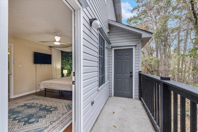 doorway to property with ceiling fan and a balcony