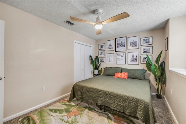 carpeted bedroom with ceiling fan, a textured ceiling, and a closet