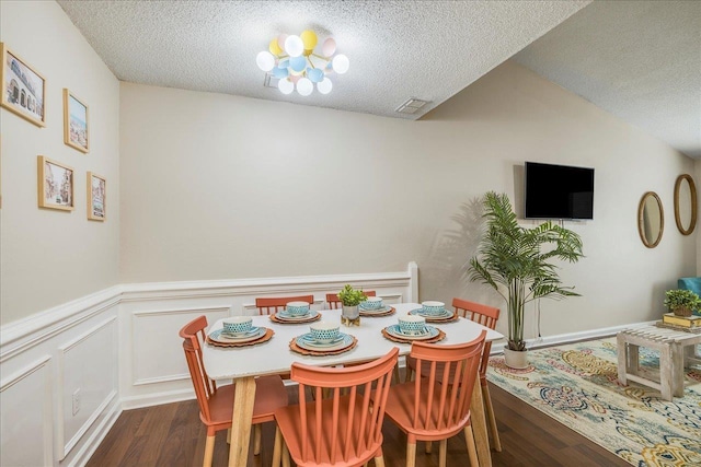 dining space featuring dark hardwood / wood-style flooring and a textured ceiling