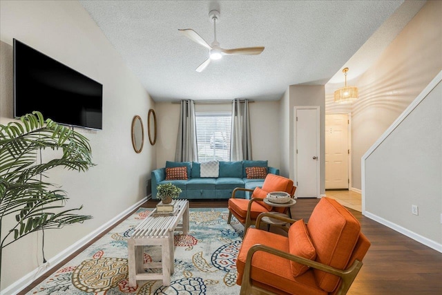 living room with hardwood / wood-style flooring, ceiling fan, and a textured ceiling