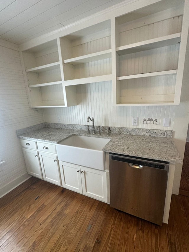 kitchen featuring stainless steel dishwasher, dark wood-type flooring, and light stone counters