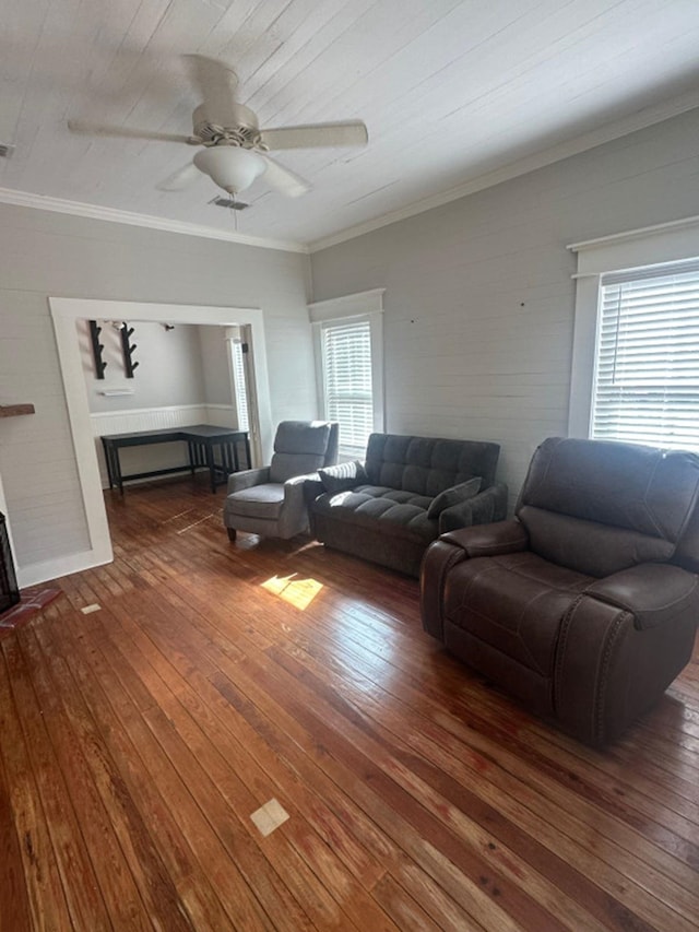 living room with ceiling fan, plenty of natural light, dark hardwood / wood-style flooring, and ornamental molding