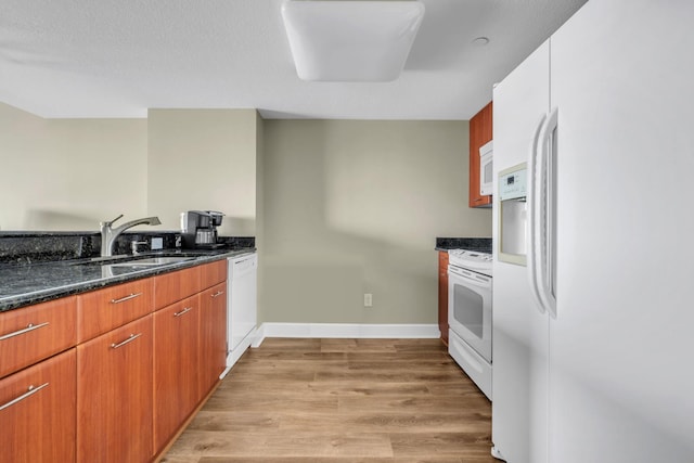 300 S Duval St Unit 1210, Tallahassee, FL 32301 - kitchen featuring white appliances, light wood-style flooring, and dark stone countertops
