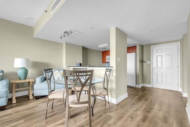 300 S Duval St Unit 1210, Tallahassee, FL 32301 - dining space with light wood-style flooring and track lighting