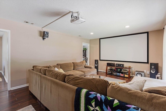 home theater featuring baseboards, visible vents, dark wood finished floors, recessed lighting, and a textured ceiling