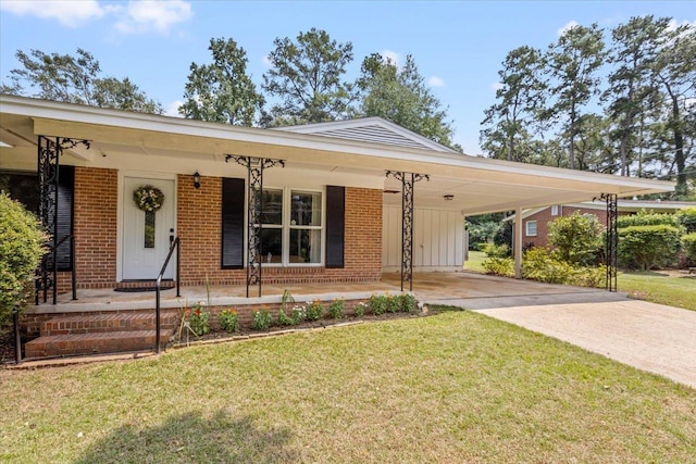 view of front of property featuring brick siding, a front lawn, covered porch, a carport, and driveway