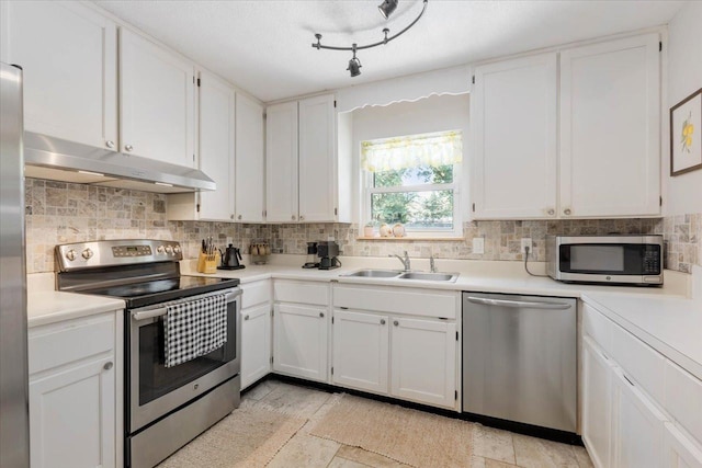 kitchen with a sink, tasteful backsplash, appliances with stainless steel finishes, and under cabinet range hood