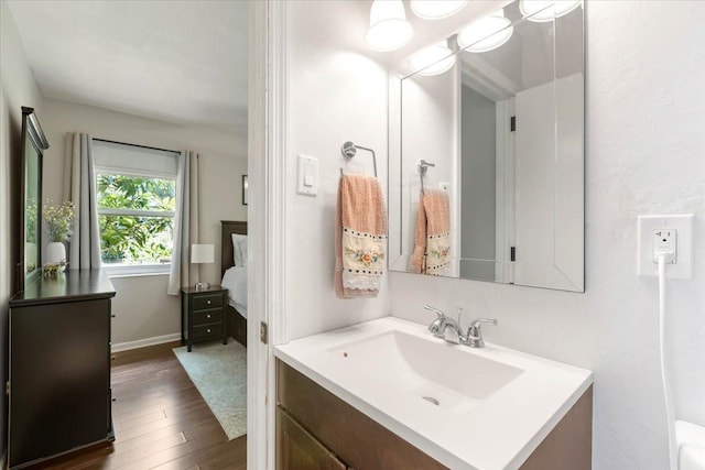 ensuite bathroom featuring vanity, ensuite bathroom, baseboards, and wood finished floors