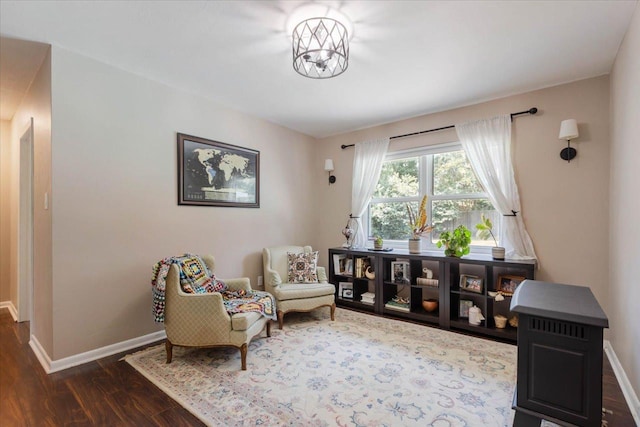 sitting room with baseboards and dark wood finished floors