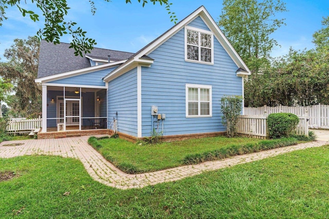 back of house with a yard, fence, and a sunroom