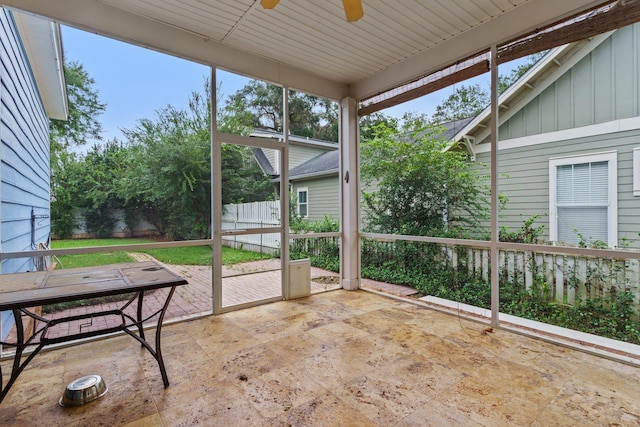 unfurnished sunroom featuring a ceiling fan