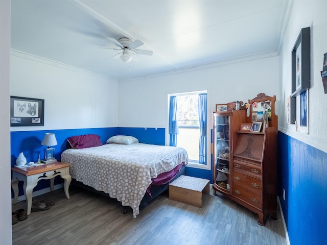 bedroom featuring ceiling fan, ornamental molding, and wood finished floors