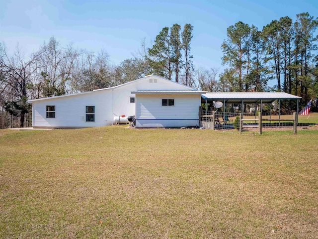 back of house featuring metal roof and a yard