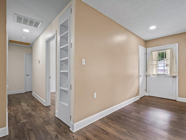 hall featuring baseboards, visible vents, dark wood-style flooring, and recessed lighting