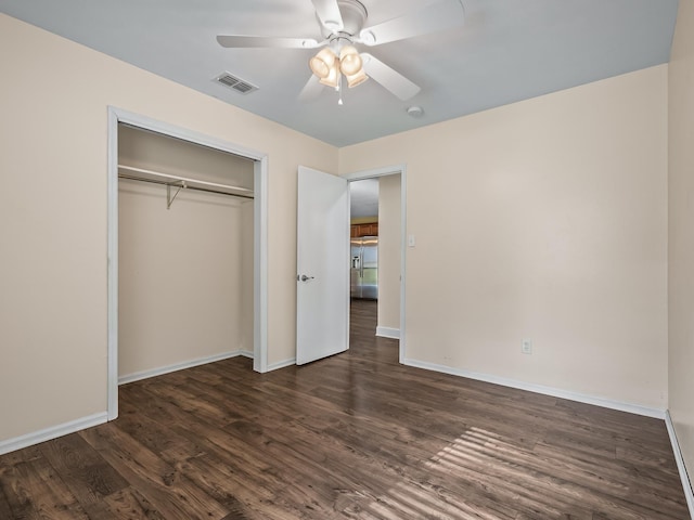 unfurnished bedroom with dark wood-style floors, a closet, visible vents, and baseboards