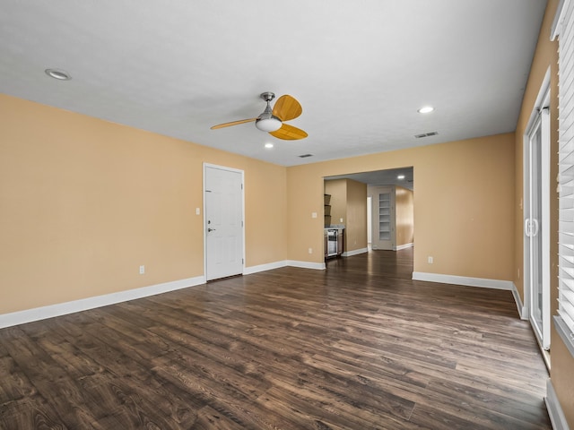 unfurnished room featuring recessed lighting, ceiling fan, dark wood-type flooring, visible vents, and baseboards