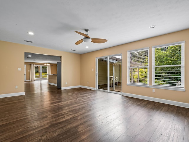 empty room featuring recessed lighting, dark wood-type flooring, a ceiling fan, visible vents, and baseboards