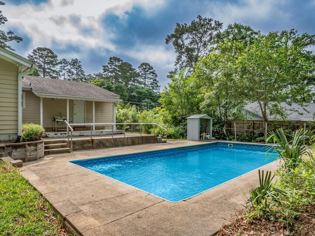 view of pool featuring a fenced in pool, a patio area, a shed, an outbuilding, and fence