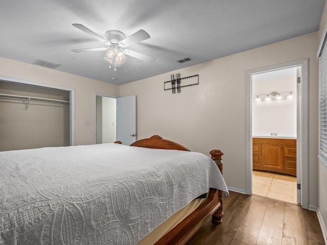 bedroom with a ceiling fan, visible vents, hardwood / wood-style floors, and ensuite bathroom