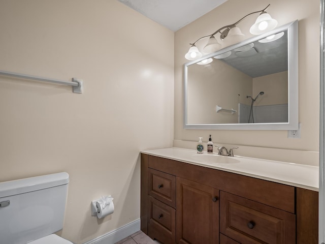 bathroom featuring tile patterned floors, vanity, toilet, and baseboards
