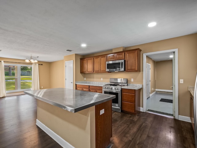 kitchen with brown cabinetry, dark wood-style flooring, appliances with stainless steel finishes, and recessed lighting