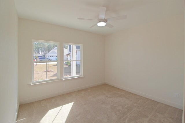 spare room featuring light carpet and ceiling fan