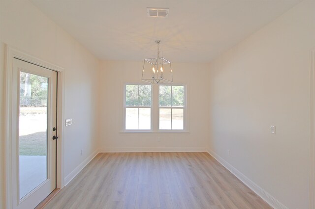 unfurnished dining area with light wood-type flooring and a notable chandelier