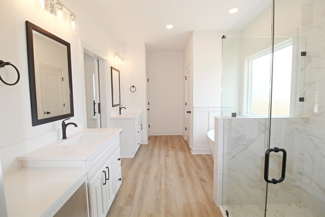 bathroom with wood-type flooring, vanity, and a shower with door