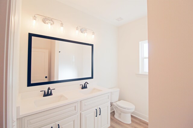 bathroom with hardwood / wood-style floors, vanity, and toilet