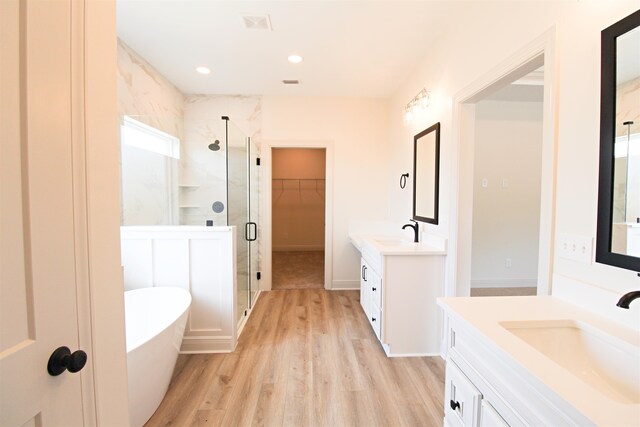 bathroom featuring hardwood / wood-style floors, shower with separate bathtub, and vanity