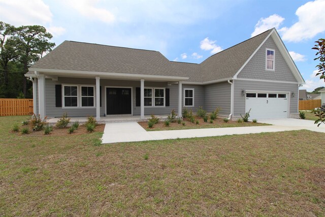 view of front of house featuring a garage, a porch, and a front lawn