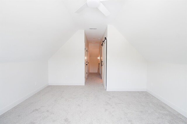 additional living space featuring light carpet, ceiling fan, and vaulted ceiling