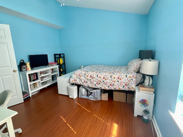 bedroom with dark hardwood / wood-style flooring