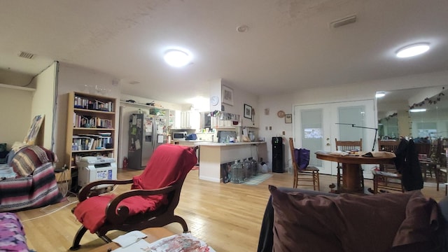 living room with light wood-type flooring and french doors