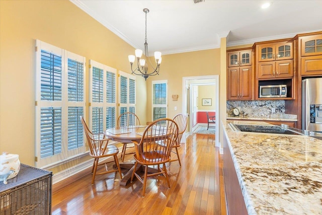 dining room featuring ornamental molding, light hardwood / wood-style flooring, and plenty of natural light