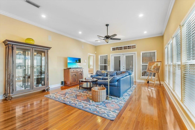 living room featuring crown molding, light hardwood / wood-style floors, french doors, and ceiling fan