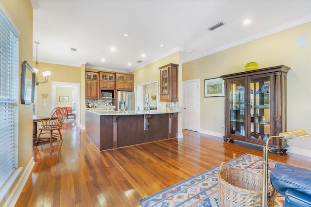 kitchen with light stone counters, stainless steel appliances, dark hardwood / wood-style floors, and backsplash