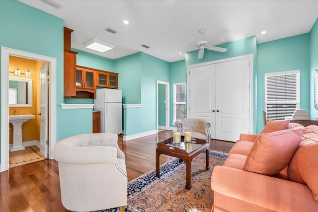 living room featuring ceiling fan, dark hardwood / wood-style floors, and sink