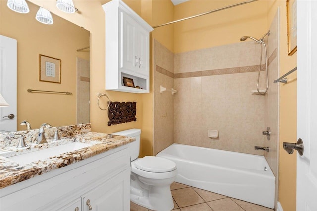 full bathroom featuring tiled shower / bath, vanity, tile patterned floors, and toilet