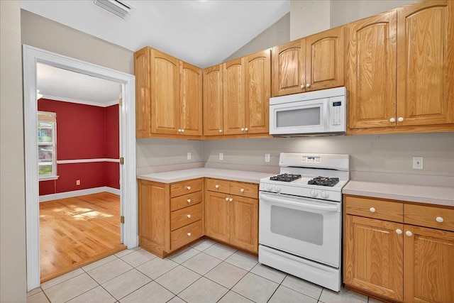 1913 Celtic Rd, Tallahassee, FL 32317 - kitchen featuring white appliances, light countertops, light tile patterned floors, vaulted ceiling, and ornamental molding