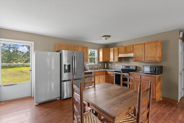 1439 W Lyman Hendry Rd, Perry, FL 32347 - kitchen with appliances with stainless steel finishes, dark wood-style floors, light countertops, and under cabinet range hood